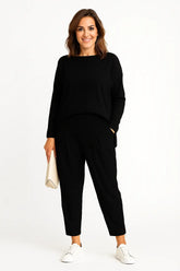 Mulher usando conjunto esportivo feminino com blusa irregular de manga longa e calça harem soltinha, ideal para a Primavera/Verão